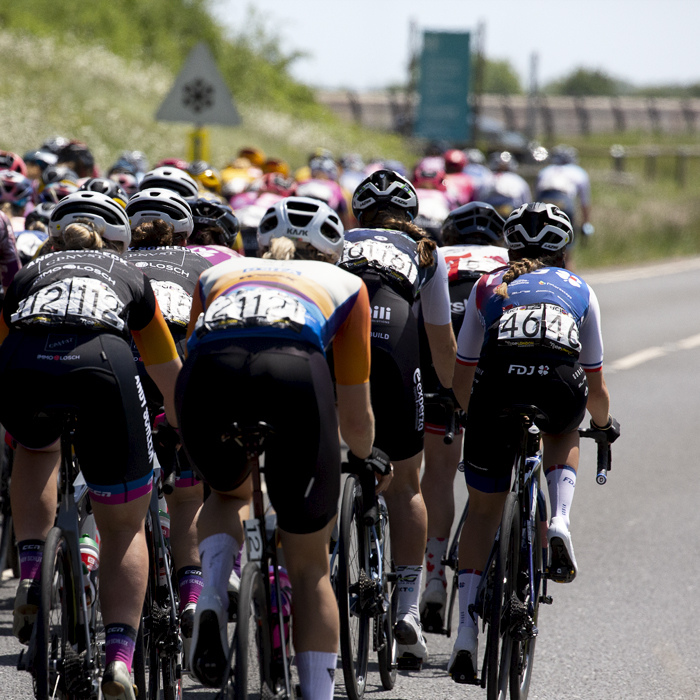 RideLondon Classique 2022 - The back of the peloton as it makes its way off the reservoir dam