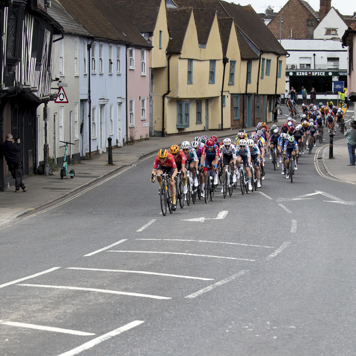 RideLondon Classique 2024 - Riders pass by a row of brightly painted houses in Colchester