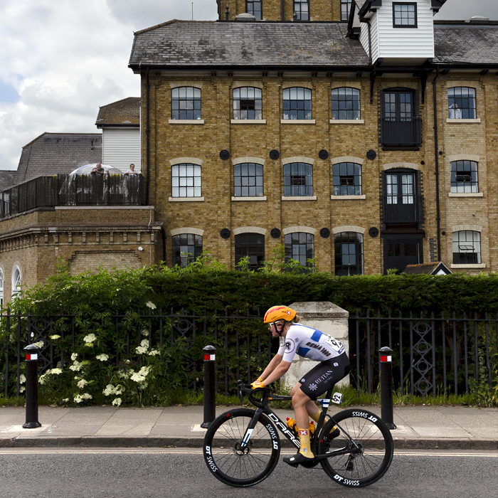 RideLondon Classique 2024 - Uno-X Mobility rider Anniina Ahtosalo passes by a mill building in Colchester