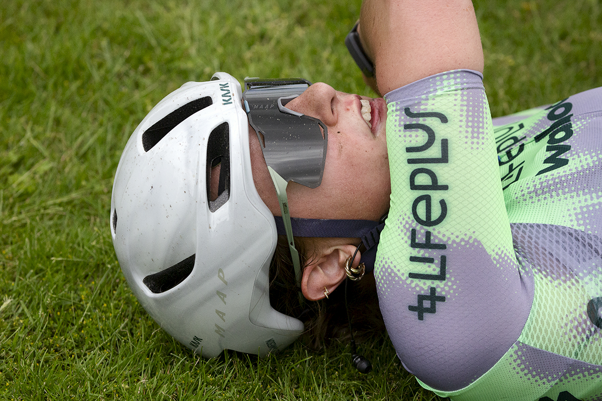 RideLondon Classique 2024 - Ella Jamieson of Lifeplus Wahoo lays on the grass exhausted after stage one