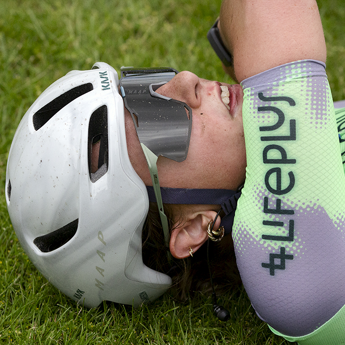 RideLondon Classique 2024 - Ella Jamieson of Lifeplus Wahoo lays on the grass exhausted after stage one