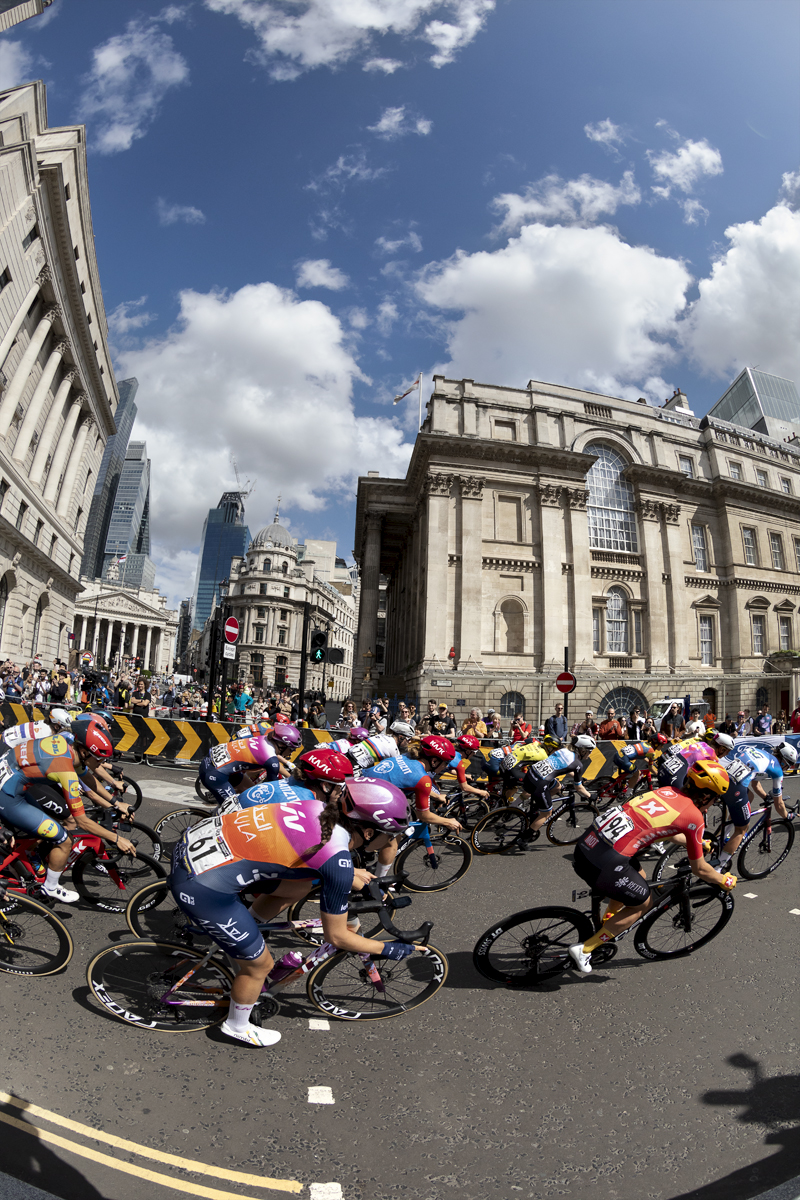 RideLondon Classique 2024 - The peloton takes a corner at Bank with the City of London in the background