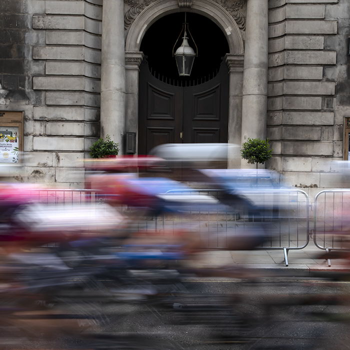 RideLondon Classique 2024 - The peloton speeds past the ornate doorway of St Mary-le-Bow Church on Cheapside in London