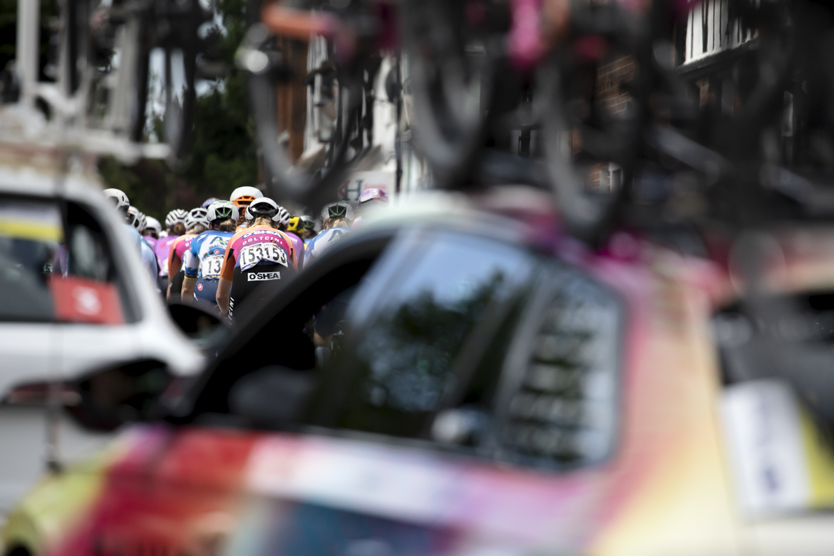 RideLondon Classique 2024 - Riders are framed by team cars in an array of colour