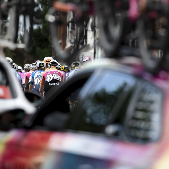 RideLondon Classique 2024 - Riders are framed by team cars in an array of colour