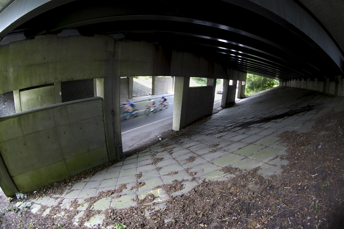 RideLondon Classique 2024 - Riders speed under a concrete bridge