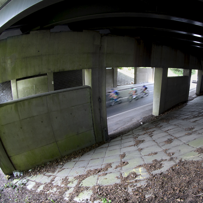 RideLondon Classique 2024 - Riders speed under a concrete bridge