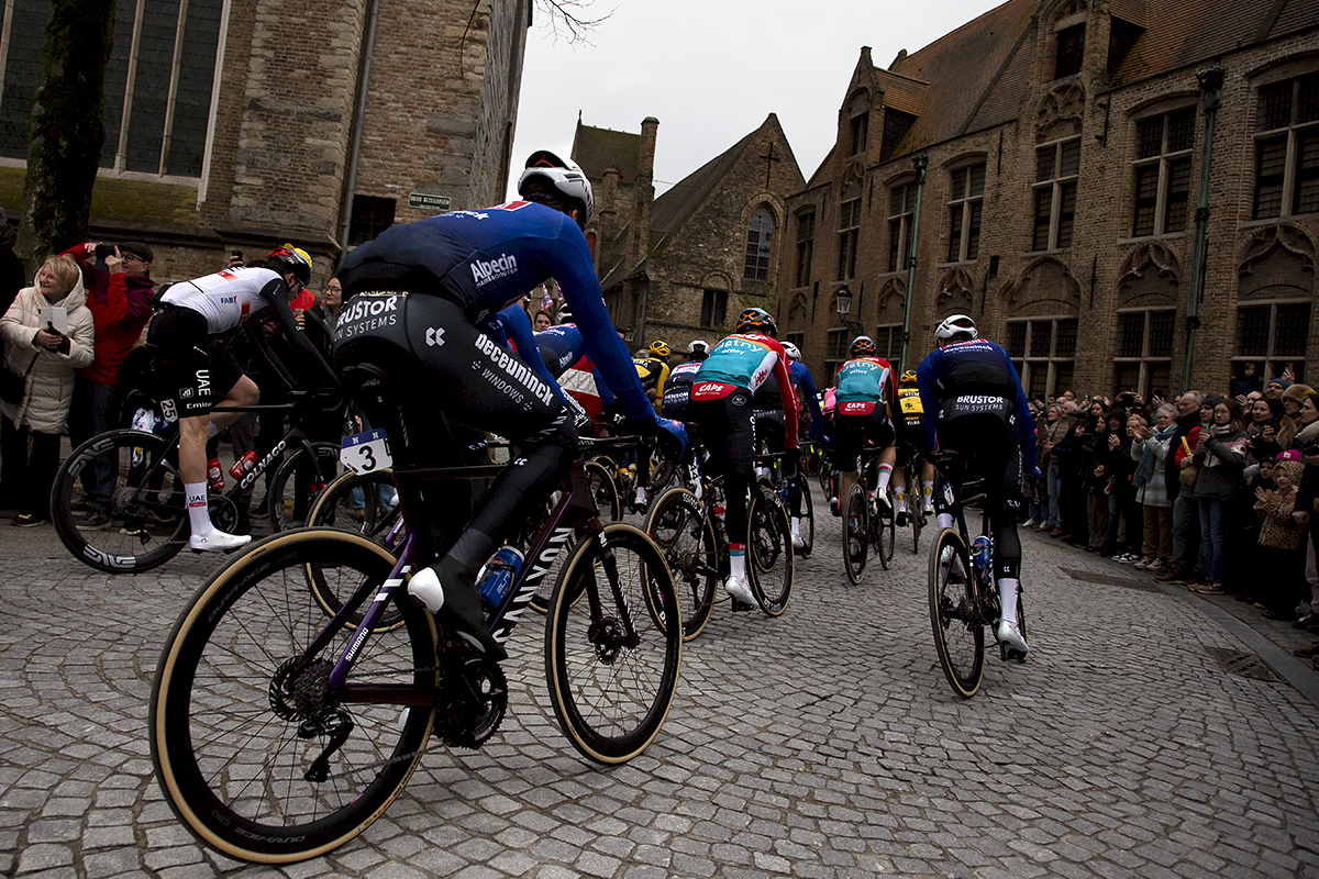 Ronde van Vlaanderen 2023 - The riders round a corner and move off through the cobbled streets of Brugge