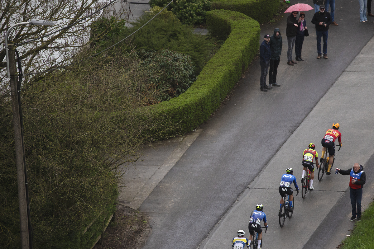 Ronde van Vlaanderen 2024 - A view from above as a soigneur holds out bidons