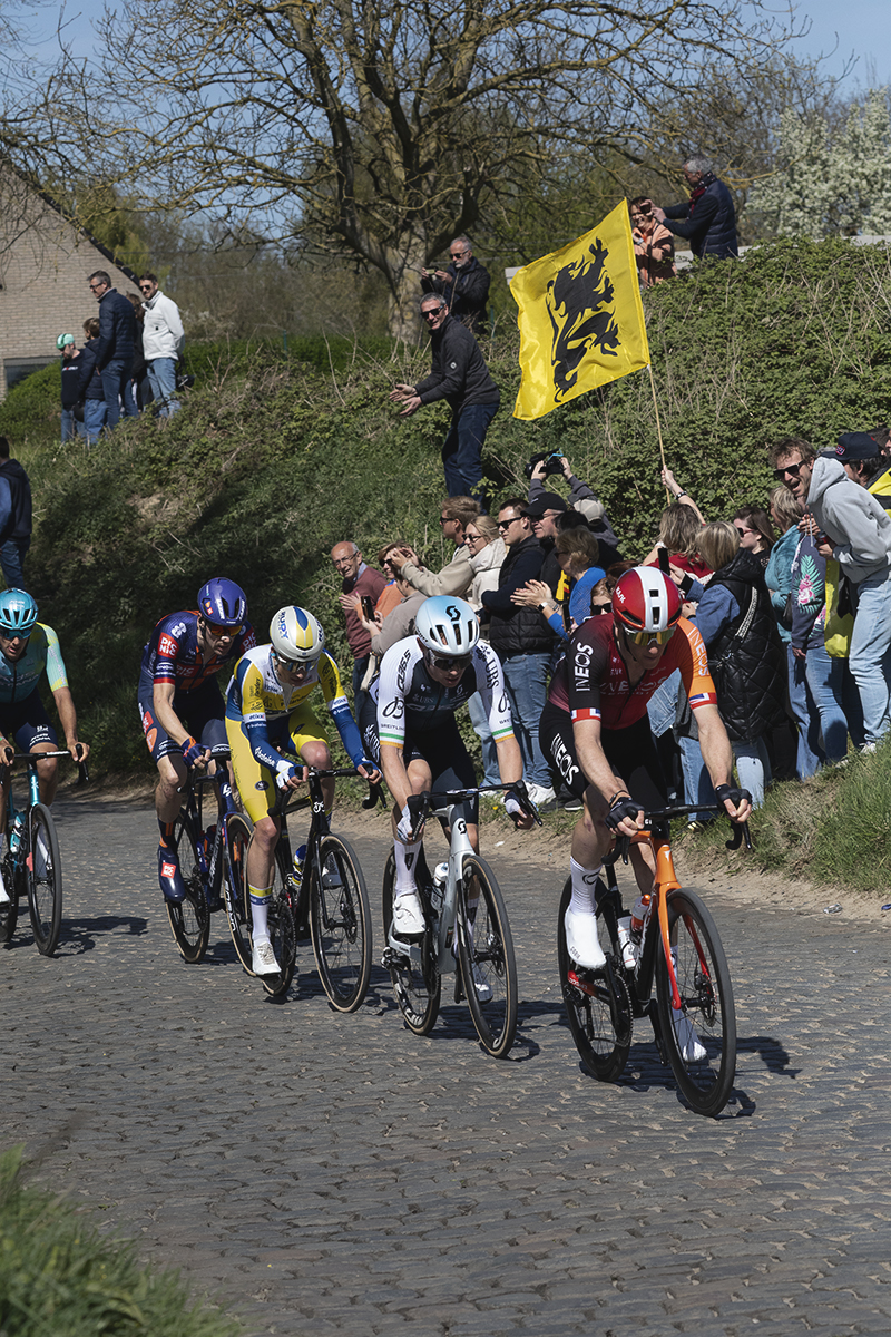 Ronde van Vlaanderen 2025 - Fans fly flags of Flanders as the breakaway takes to the cobbles on Holleweg