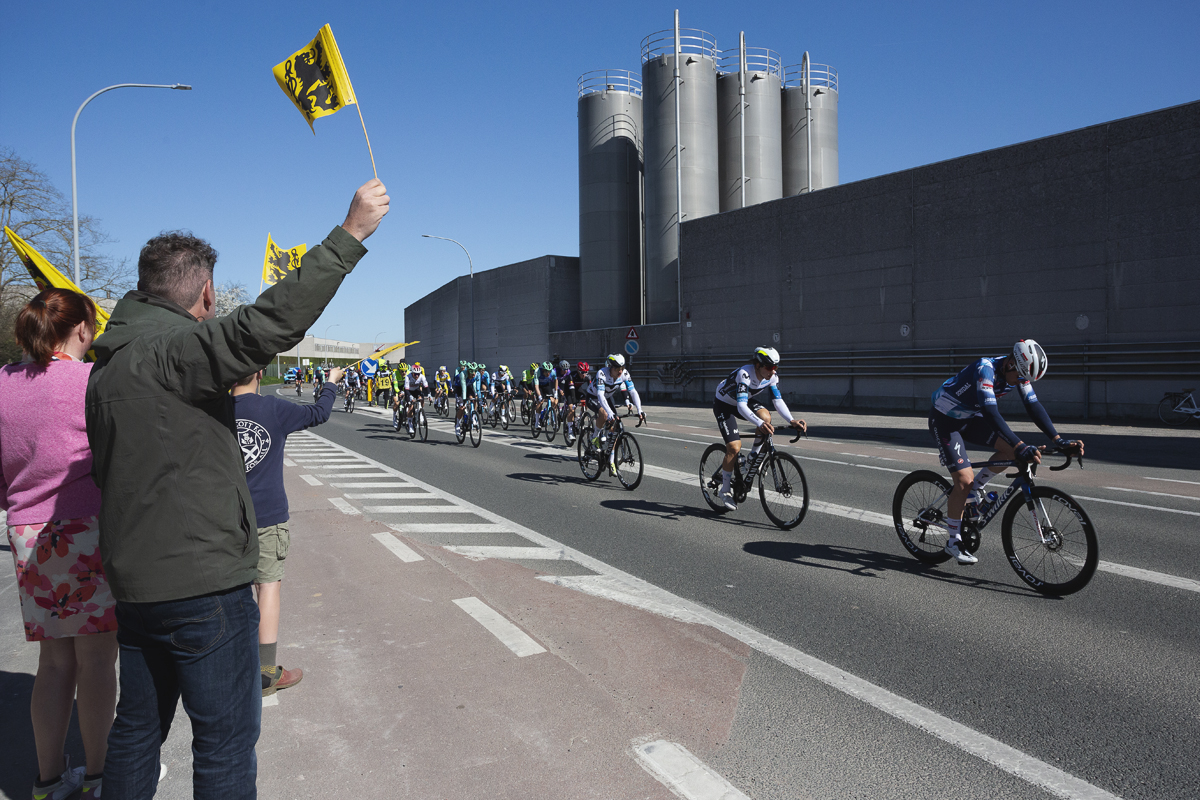 Ronde van Vlaanderen 2025 - A family wave flags of Flanders as the race passes in Sint-Baafs-Vijve