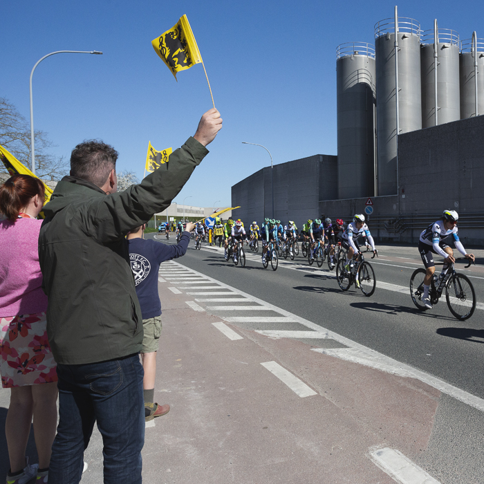Ronde van Vlaanderen 2025 - A family wave flags of Flanders as the race passes in Sint-Baafs-Vijve
