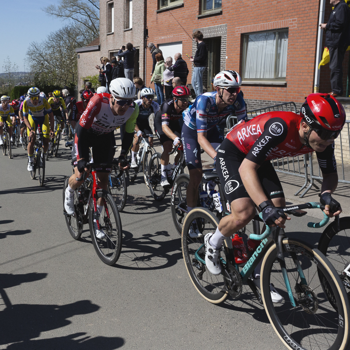 Ronde van Vlaanderen 2025 - Riders on the climb of Wolvenberg with fans using the walls of houses as a vantage point
