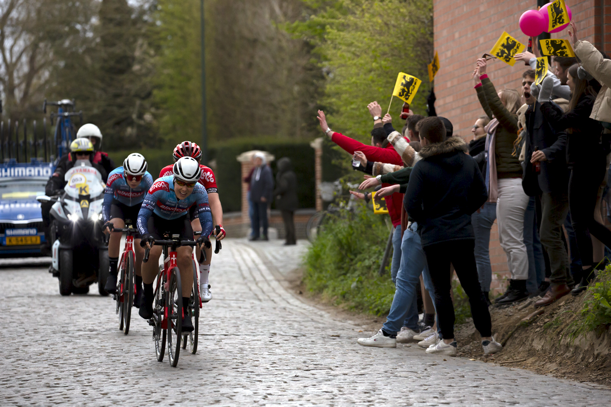 Ronde van Vlaanderen Vrouwen 2022 - Naomi de Roeck of Bingoal Casino - Chevalmeire - Van Eyck Sport passes a group of fans waving Flanders flags