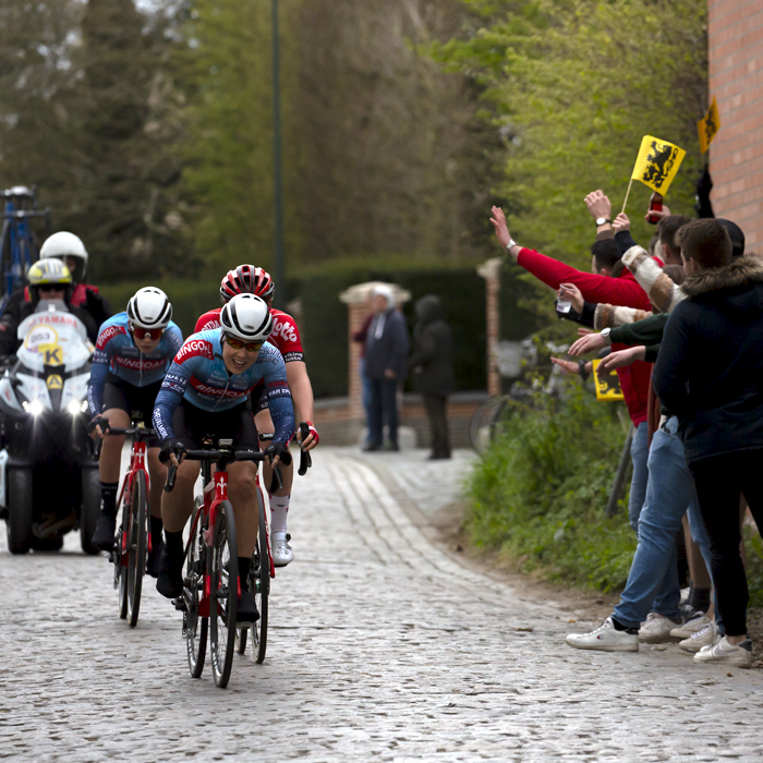 Ronde van Vlaanderen Vrouwen 2022 - Naomi de Roeck of Bingoal Casino - Chevalmeire - Van Eyck Sport passes a group of fans waving Flanders flags