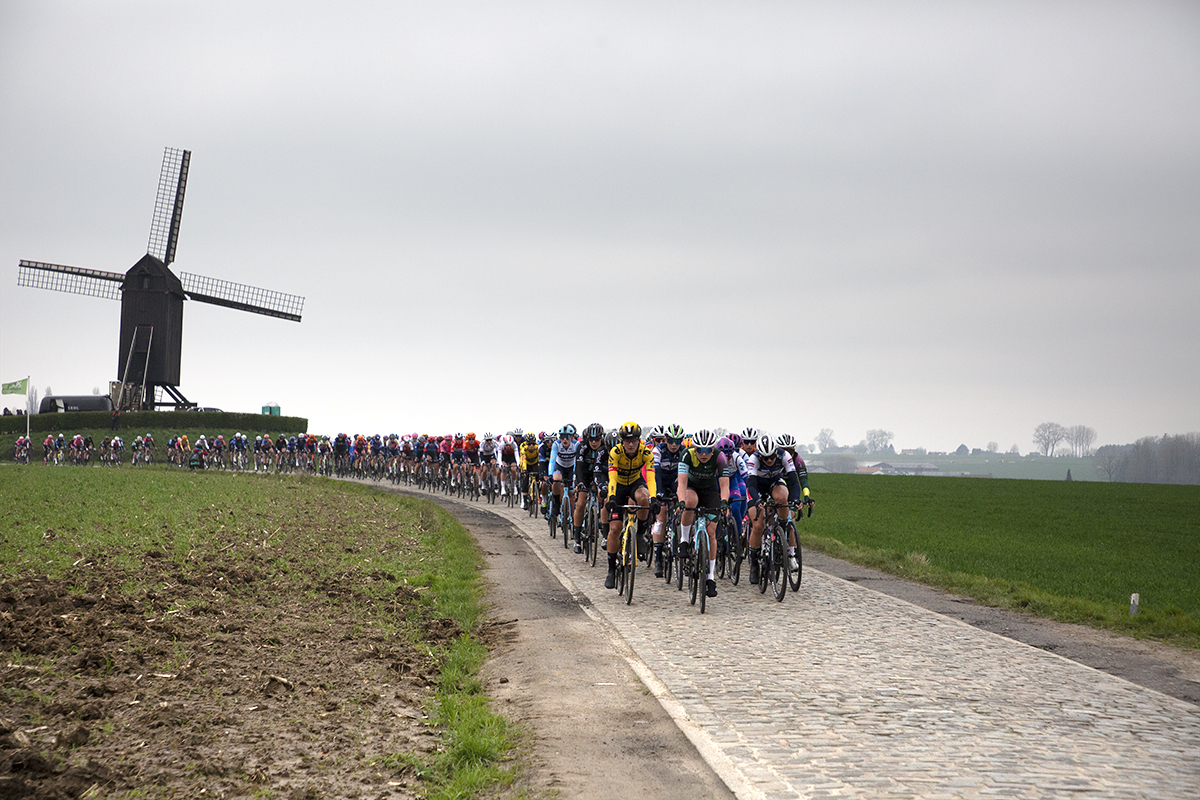 Ronde van Vlaanderen Vrouwen 2023 - The peloton on Huisepontweg with the windmill in the background