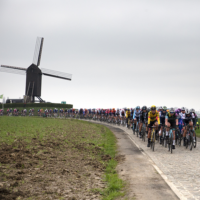 Ronde van Vlaanderen Vrouwen 2023 - The peloton on Huisepontweg with the windmill in the background