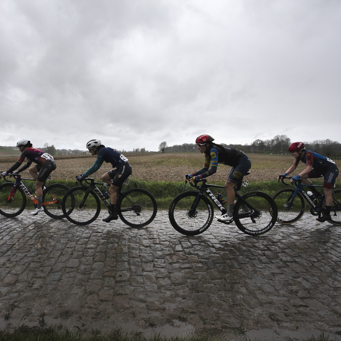 Ronde van Vlaanderen Vrouwen 2024 - Riders wearing rain jackets as they race on wet cobbles on Mariaborrestraat