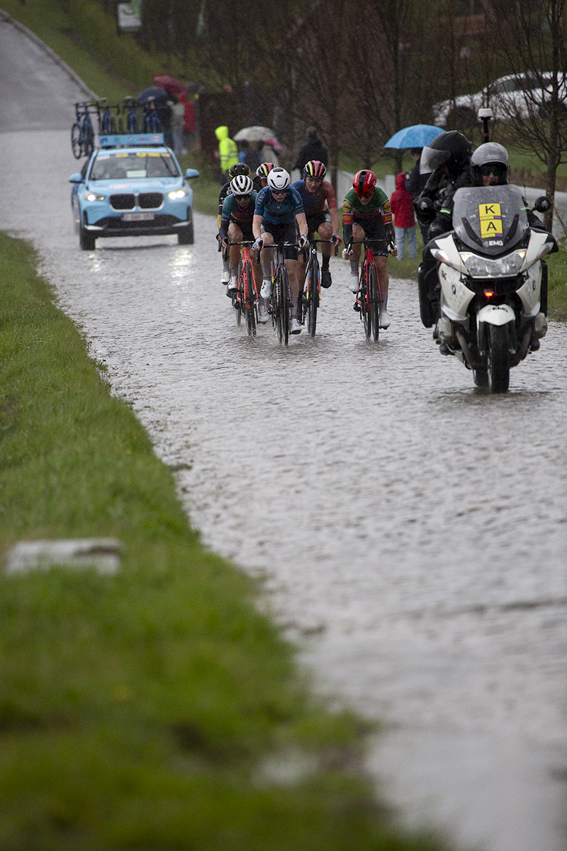 Ronde van Vlaanderen Vrouwen 2024 - Fans shelter under umbrellas as riders approach on Mariaborrestraat