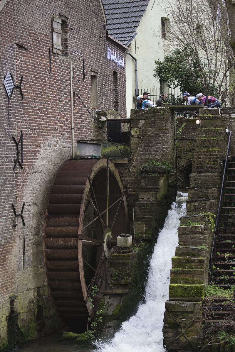 Ronde van Vlaanderen Vrouwen 2024 - Riders seen crossing the mill stream with the waterwheel clearly visible