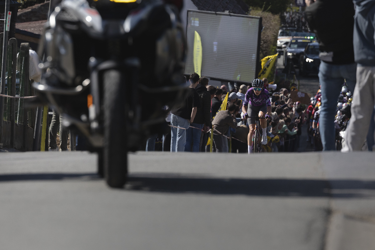 Ronde van Vlaanderen Vrouwen 2025 - Quinty Ton on Berendries, crowds in the background gather beneath a large screen showing the men’s race