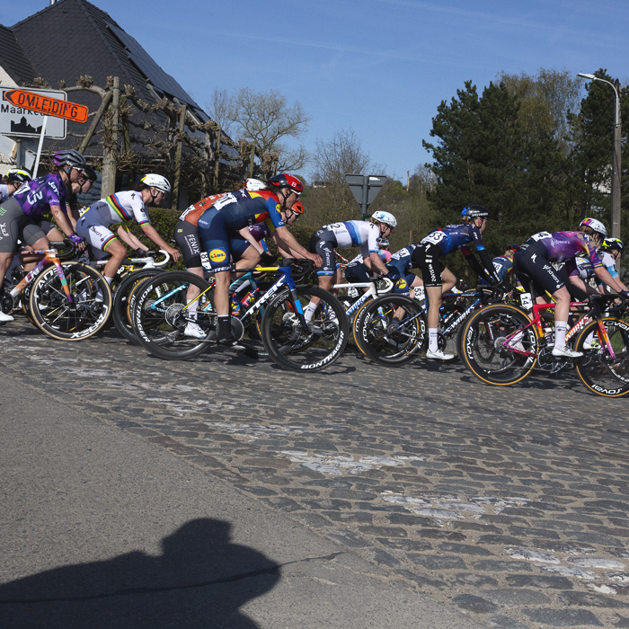 Ronde van Vlaanderen Vrouwen 2025 - Riders take a corner onto the cobbles in Maarkedal