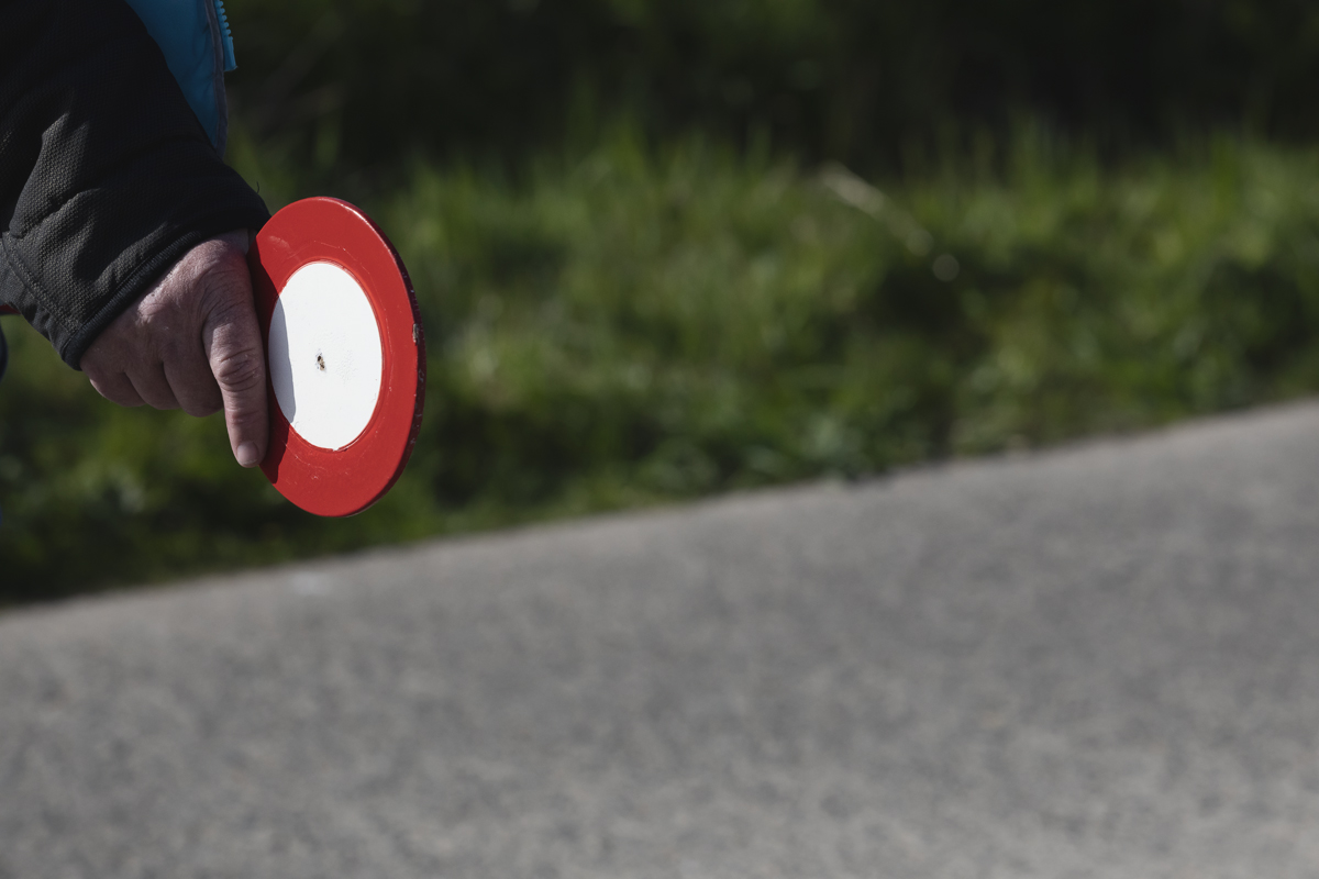Ronde van Vlaanderen Vrouwen 2025 - A sign is held by one of the Signaalgevers