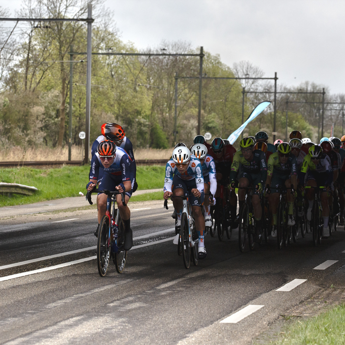 Scheldeprijs 2024 - A group of riders race past train lines near Rilland