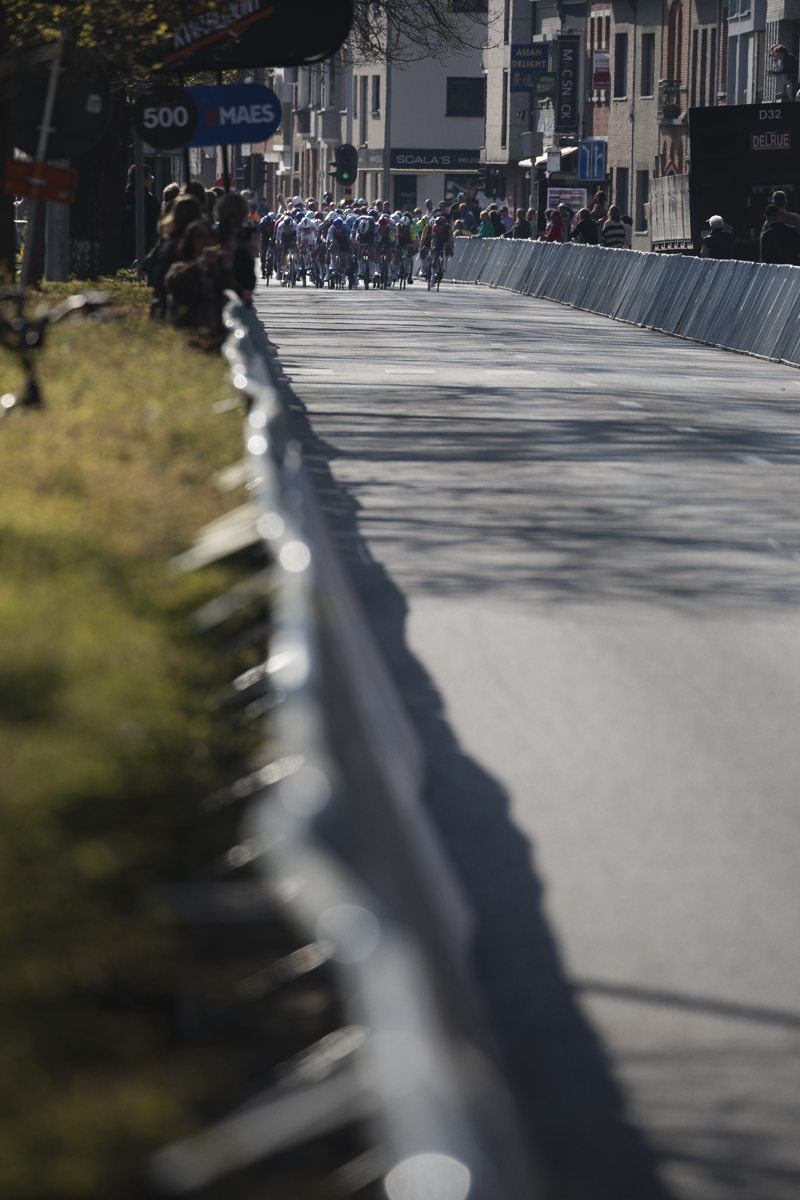 Scheldeprijs 2025 - The peloton sprints down the barrier lined finish straight in Schoten