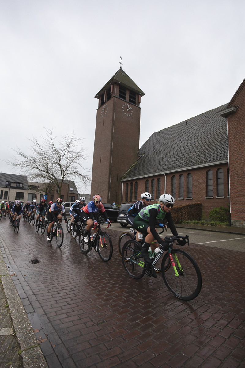 Scheldeprijs Vrouwen 2024 - The peloton passes in front of the church in Achterbroek