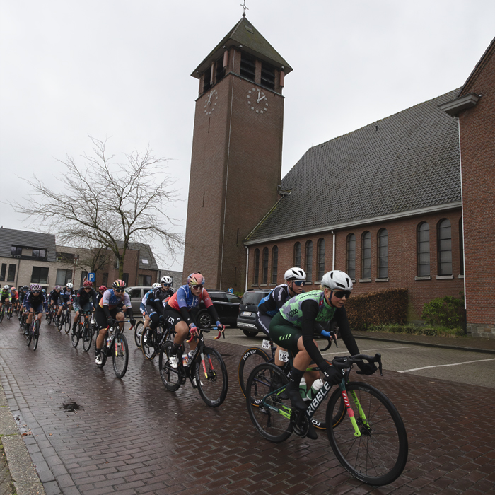 Scheldeprijs Vrouwen 2024 - The peloton passes in front of the church in Achterbroek
