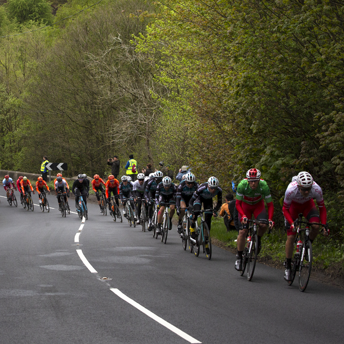 Tour de Yorkshire 2019 - A strung out peloton ascends Pot Bank - Harrogate