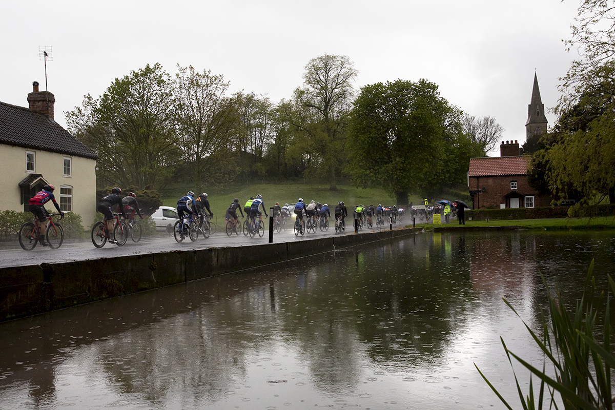 Tour de Yorkshire 2019 - The peloton pass by a pond in Warter as the rains falls