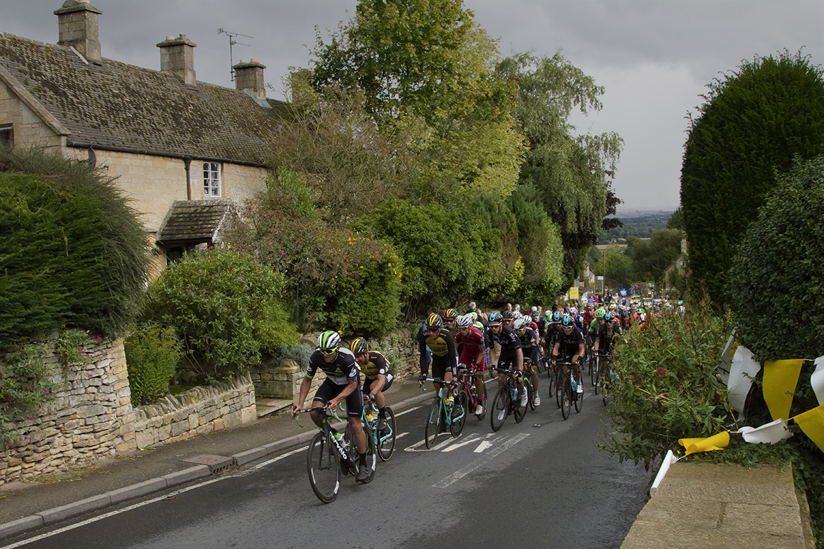 Tour of Britain 2017 - The peloton pass traditional stone buildings in Bourton-on-the-Hill in the Cotswolds