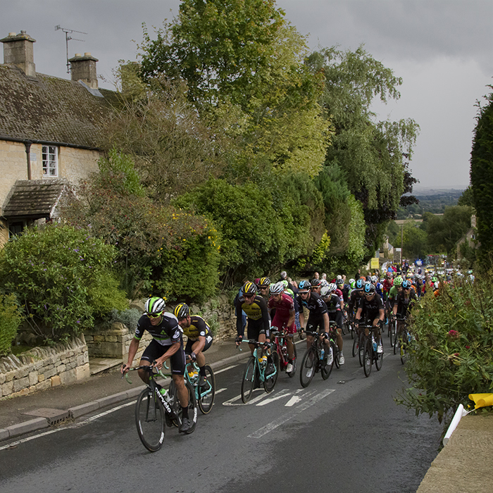 Tour of Britain 2017 - The peloton pass traditional stone buildings in Bourton-on-the-Hill in the Cotswolds