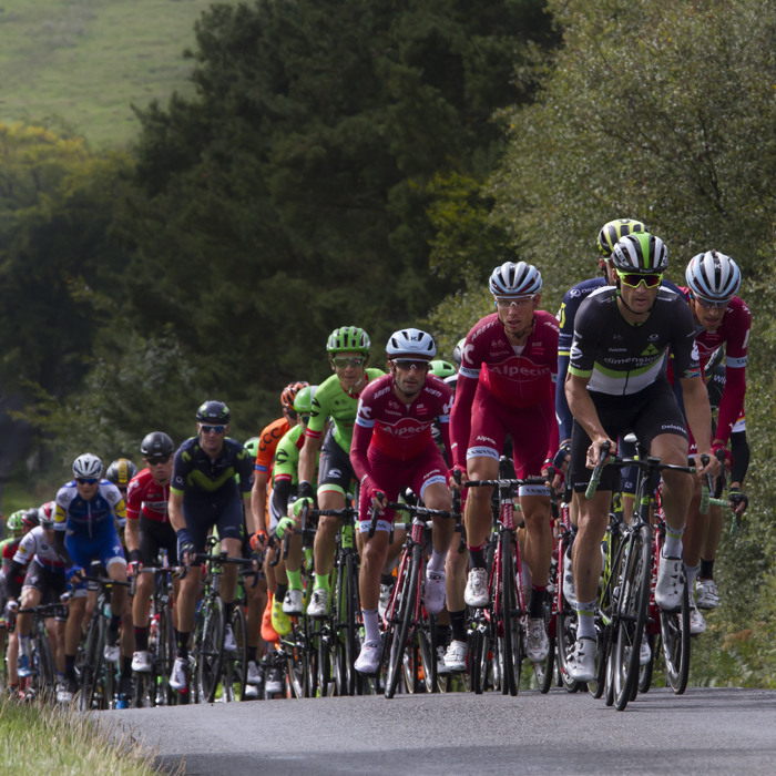 Tour of Britain 2017 - The peloton climbs a hill in the countryside near Rothbury