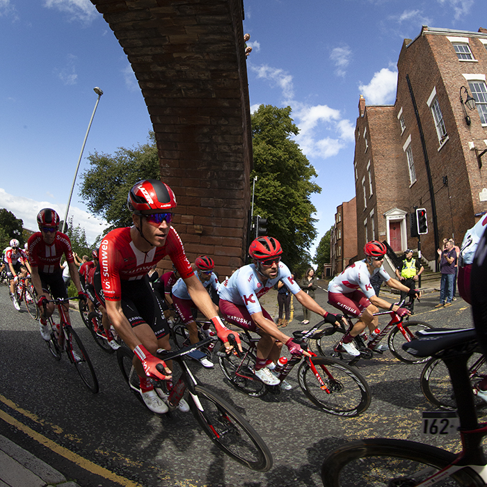 Tour of Britain 2019 - The peloton round the corner having passed under the walls at Chester