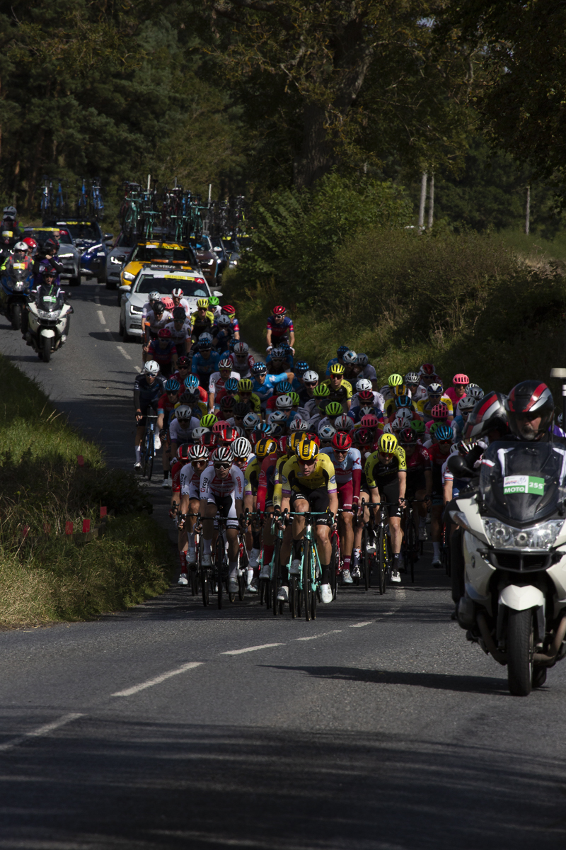 Tour of Britain 2019 - the peloton heads up a road on the outskirts of Kelso