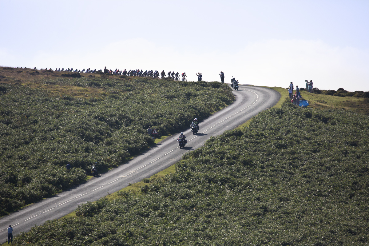 Tour of Britain 2021 - Peloton on the horizon about to crest a hill and descend in Dartmoor