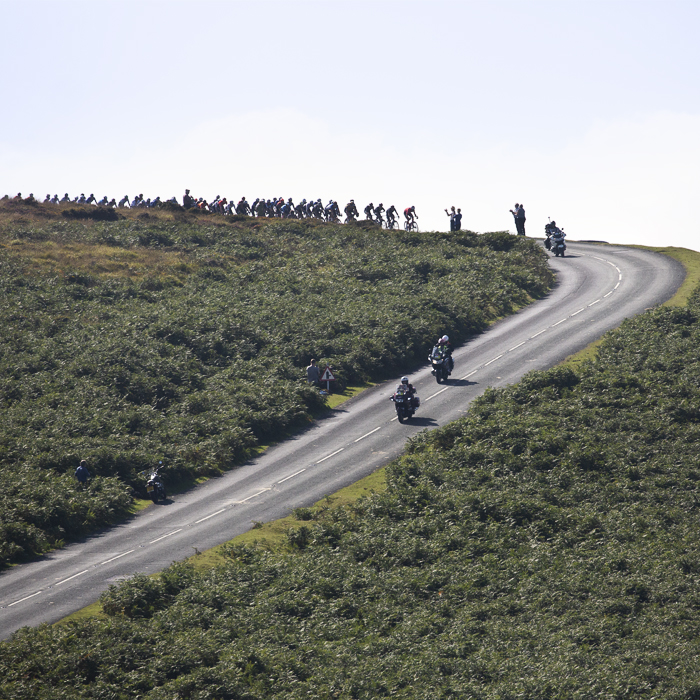 Tour of Britain 2021 - Peloton on the horizon about to crest a hill and descend in Dartmoor