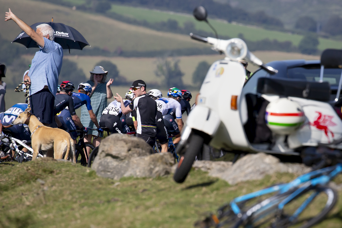 Tour of Britain 2021 - Spectators shelter from the heat under umbrellas as riders pass by