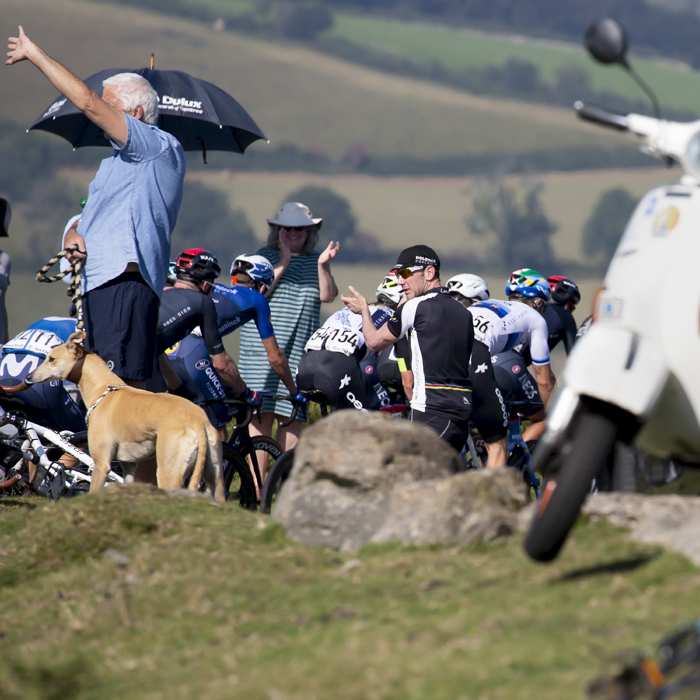 Tour of Britain 2021 - Spectators shelter from the heat under umbrellas as riders pass by