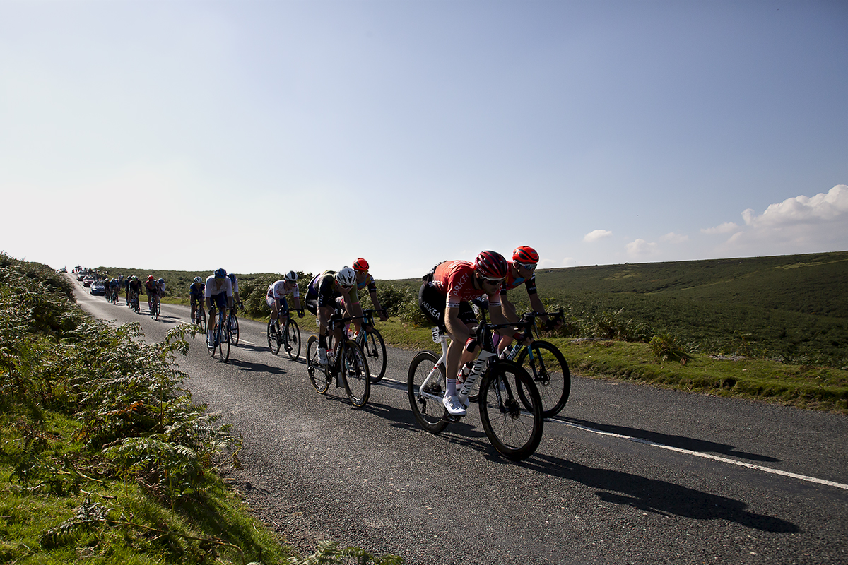 Tour of Britain 2021 - Long shadows can be seen as riders descend the moor in Dartmoor