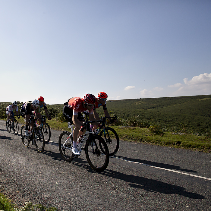 Tour of Britain 2021 - Long shadows can be seen as riders descend the moor in Dartmoor