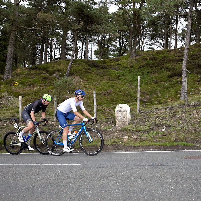 Tour of Britain 2021 - Two riders pass near a milestone on the Nenthead climb