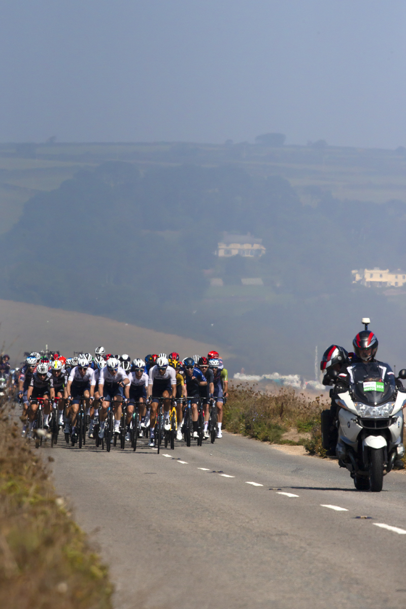 Tour of Britain 2021 - The peloton ride through heat haze along Slapton Ley