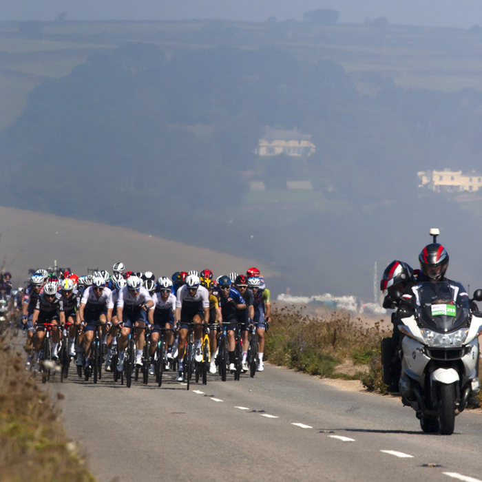 Tour of Britain 2021 - The peloton ride through heat haze along Slapton Ley