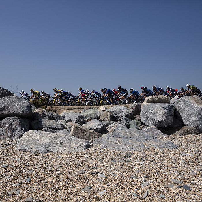 Tour of Britain 2021 - Side view of the peloton taken from the pebble beach on Slapton Ley