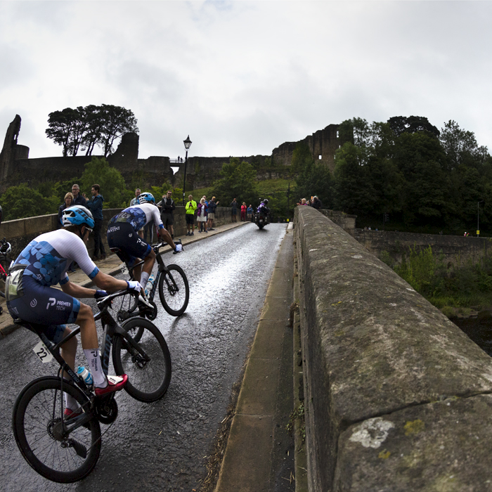 Tour of Britain 2022 - Alex Dowsett of Israel - Premier Tech races over the bridge with Barnard Castle clearly visible in the background