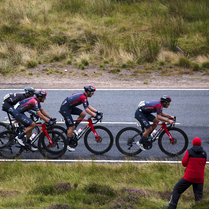 Tour of Britain 2022 - INEOS Grenadiers pass a fan at the side of the Cairnwell Pass on the way to the finish of Stage 1